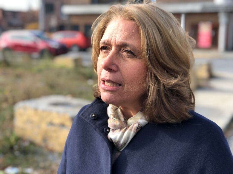 A woman speaking to a reporter. 