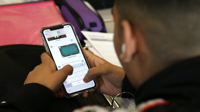 A kid texting using a cellphone.