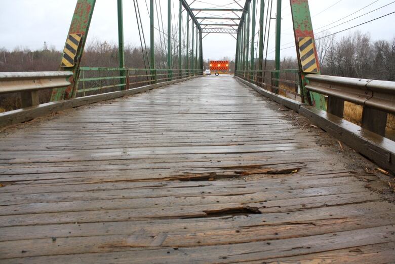 Photo of a wood lined bridge surface.