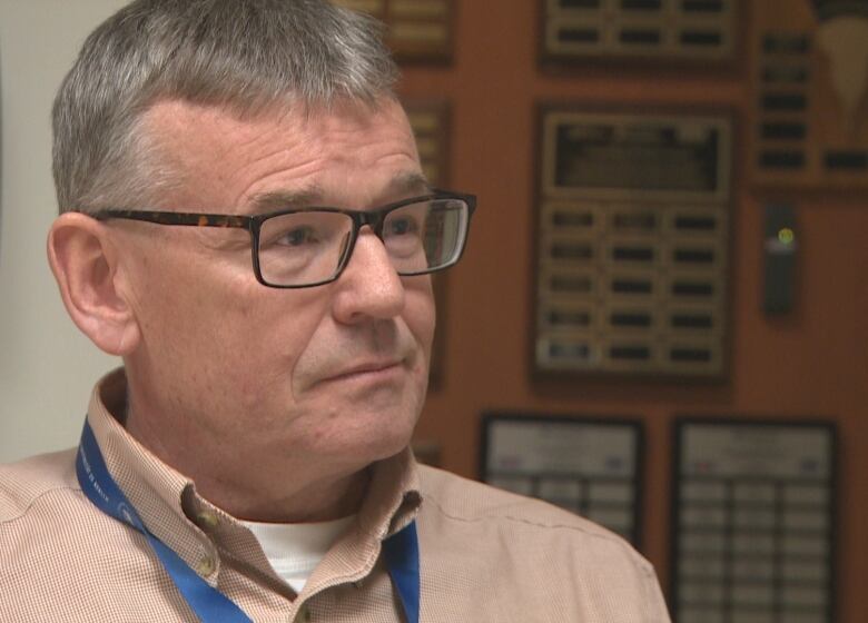 A grey-haired man in glasses.