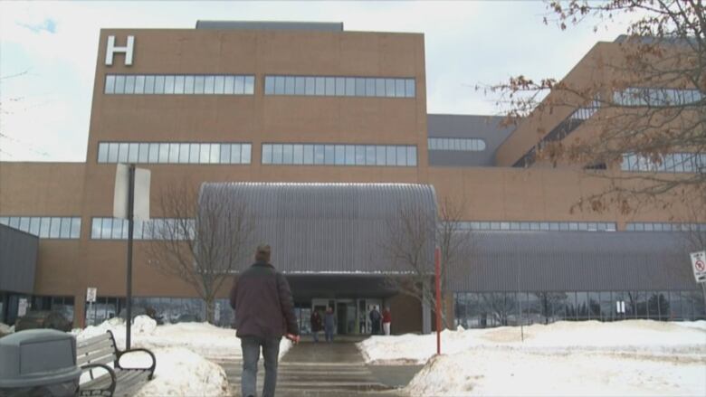 Person walking towards entrance of hospital