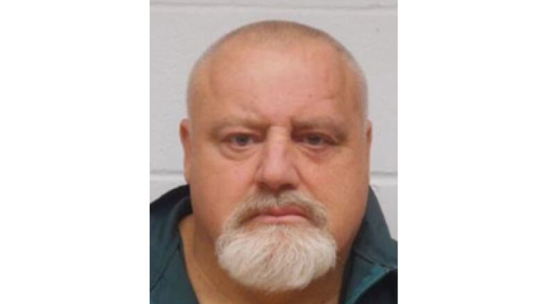 Brian Abrosimo, a white man with a bald head and grey beard, is shown in a mug shot.