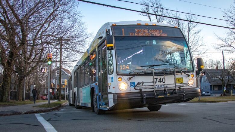 A number 1 Halifax transit bus is seen driving though an intersection.  The sign on the top reads 'Spring Garden Road to Mumford Terminal'.