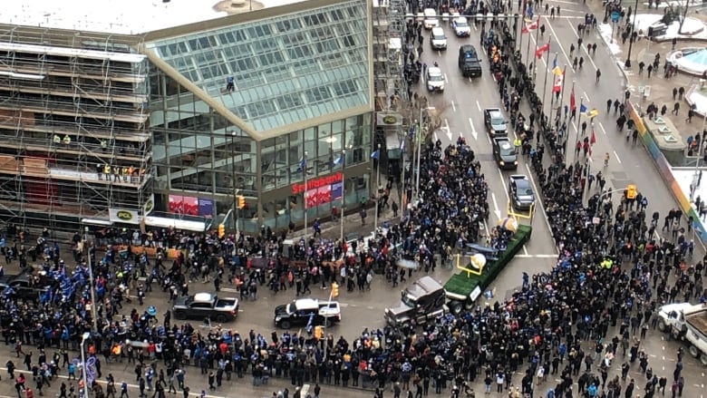 An aerial shot of people marching through an intersection.