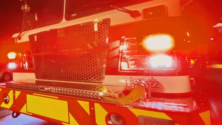 A closeup shows the front of a fire truck at night.