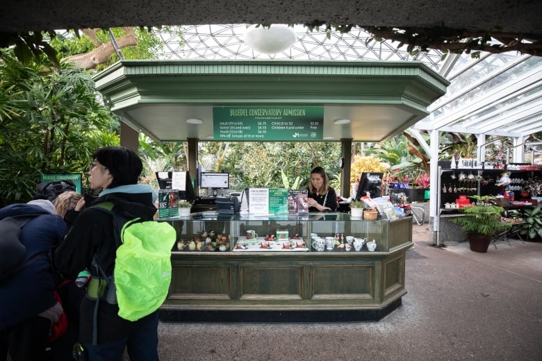 A ticket booth at the entrance to a large conservatory located within a spherical greenhouse.