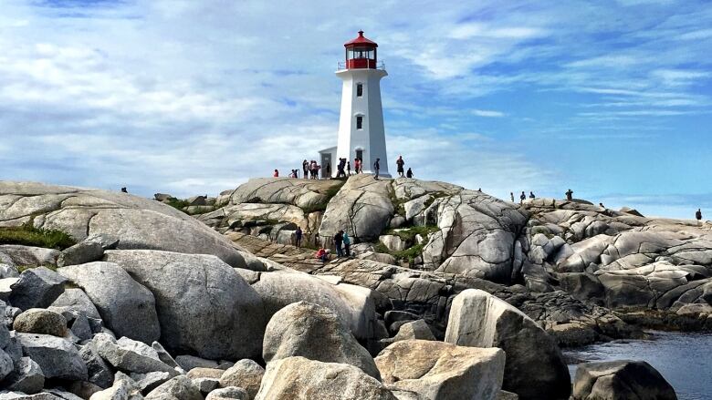 The Peggys Cove lighthouse is seen with rocks in the foreground