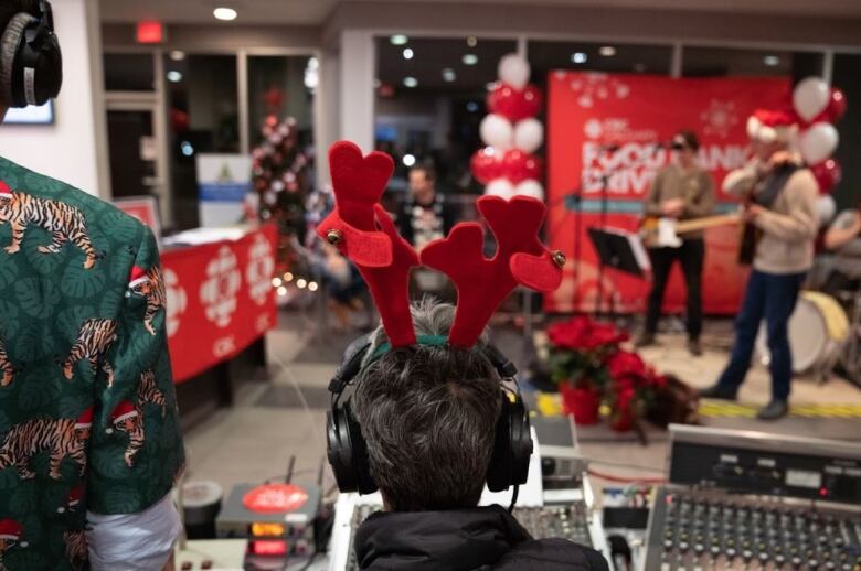 A person wearing antlers attached to a headband. 