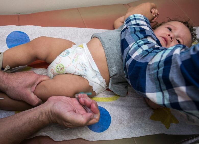 A toddler being vaccinated.