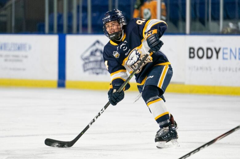 A hockey player fires the puck.