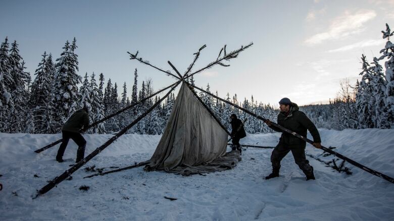 2 people raising a camp