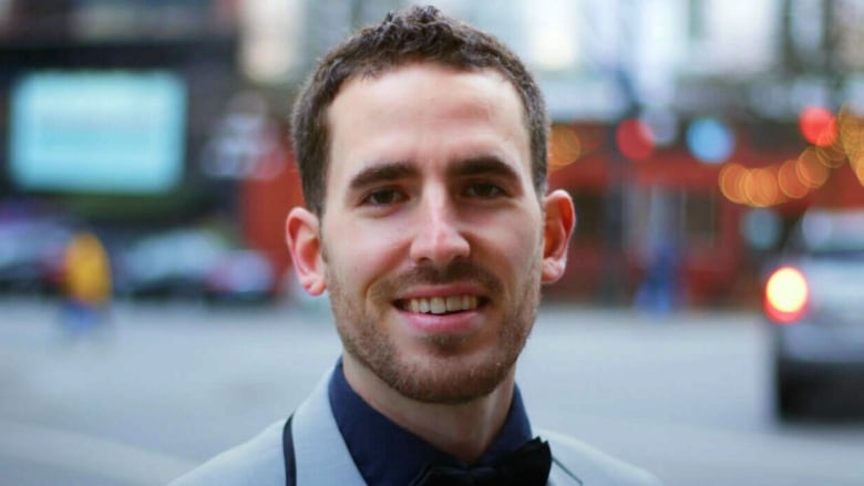 A professional head shot shows a white man with close cropped brown hair and a closely trimmed beard.