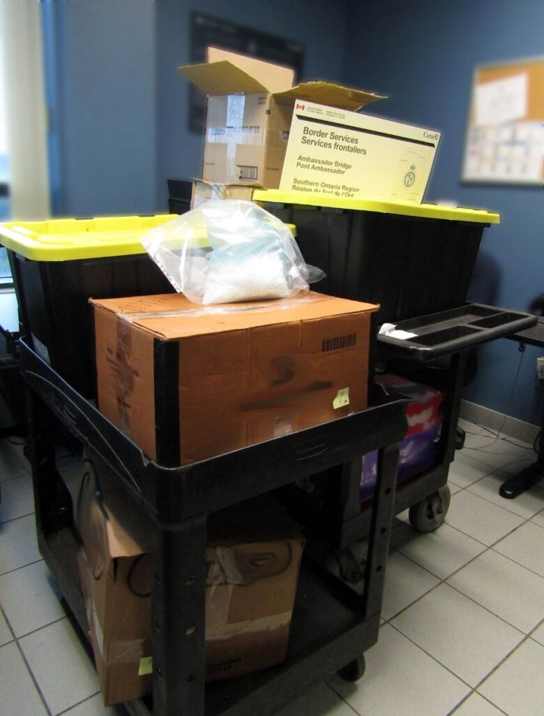 Carts full of boxes and a plastic bag with white crystals inside.