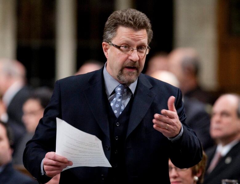 A man in a suit with a beard and glasses