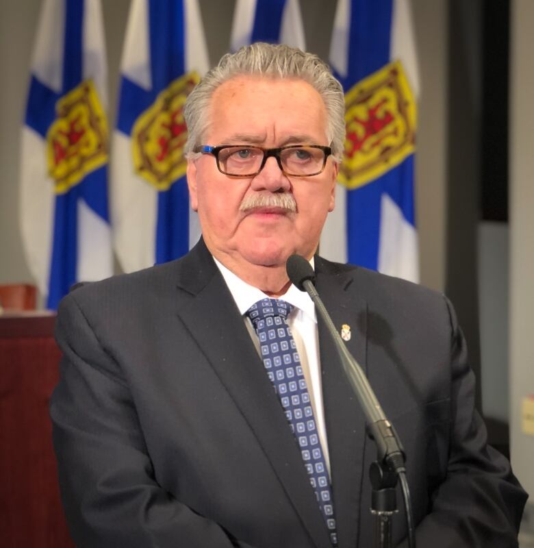 Photo of Lloyd Hines in a dark suit with a blue-patterned tie.