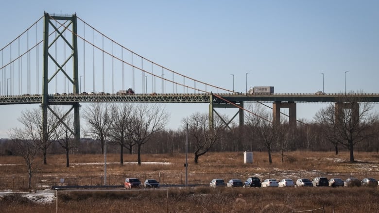 The MacKay bridge is shown over an empty field with a parking lot