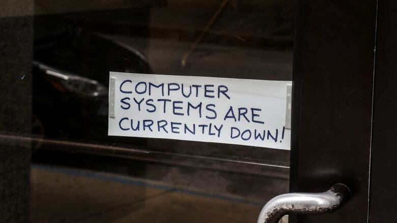 A sign taped to a door says computer systems are down.