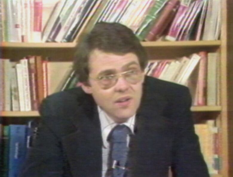 Man sitting in front of bookshelf