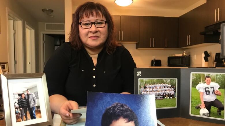 Woman holds photo of her son.