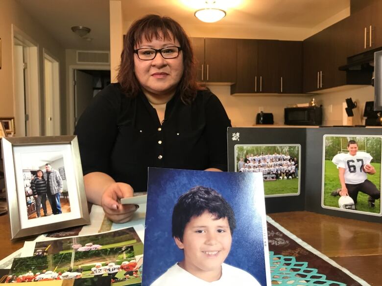 Woman holds photo of her son.