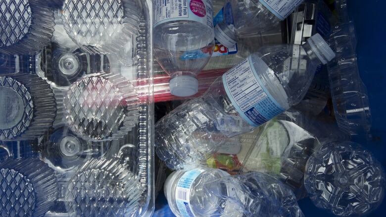 plastic containers lie on the ground piled up.