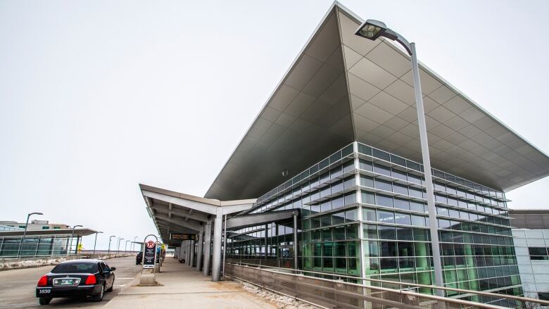 The glass-and-steel exterior of Richardson International Airport, as seen from the second-floor passenger arrival ramp.