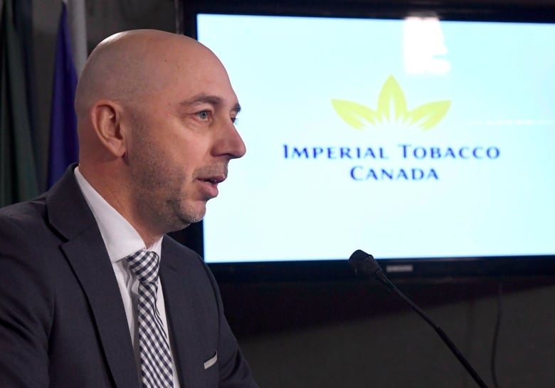 Man wearing suit speaks at podium