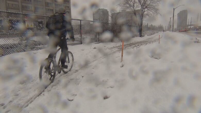 A cyclist pushes through a slushy path. There's even slush on the camera lens.