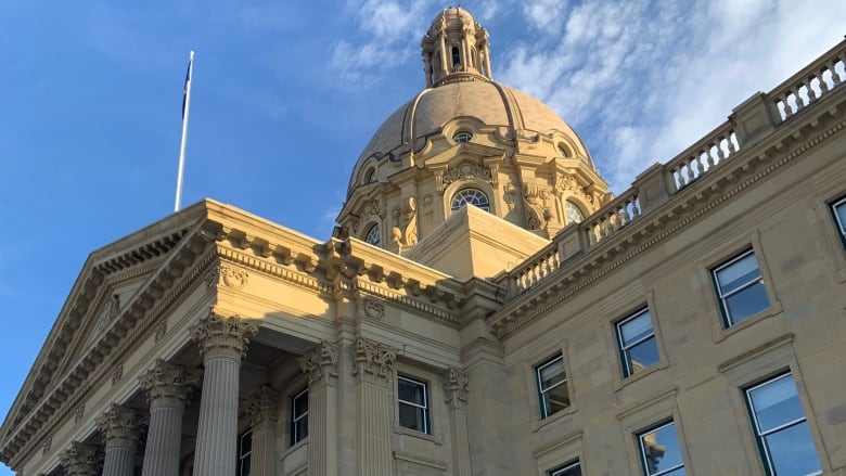 A skyward view of the Classical Revival-style Alberta Legislature building, its Corinthian columns seen on the left and its dome at the top centre of the image.