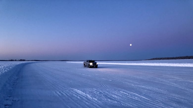 A truck drives on a frozen lake, 