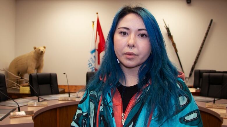 Woman with blue hair stands in council chambers