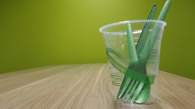 A photo of a plastic cup and forks.