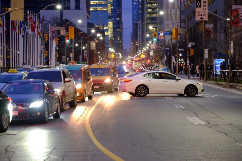 A lineup of cars on a roadway at night.