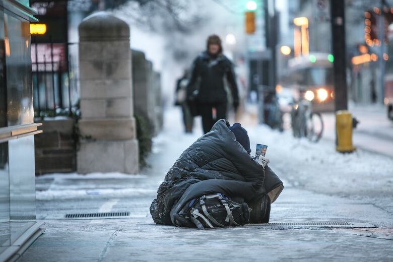 Homeless person panhandling on Toronto street.