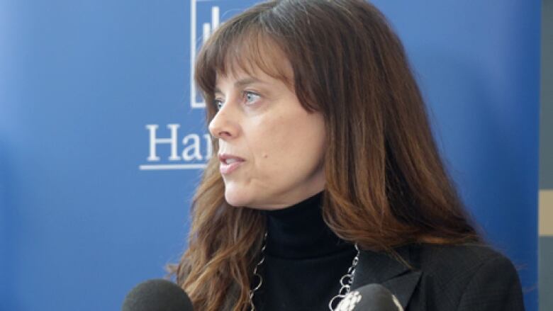 woman stands at podium