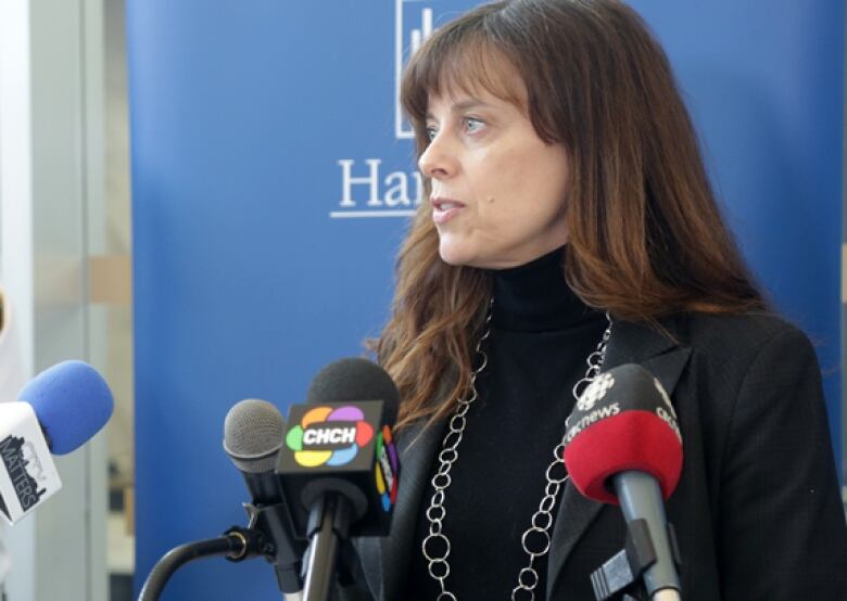 woman stands at podium