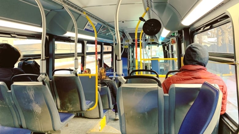 Four people sit in a bus.