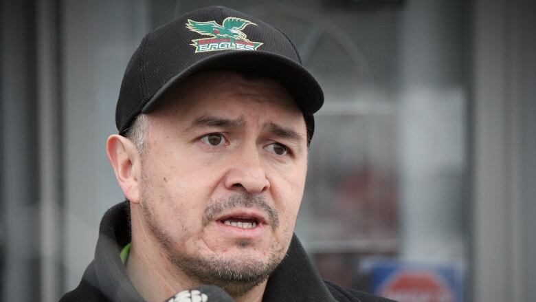 An Indigenous man in a Cape Breton eagles hat