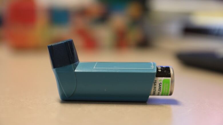 An inhaler sits on a table.