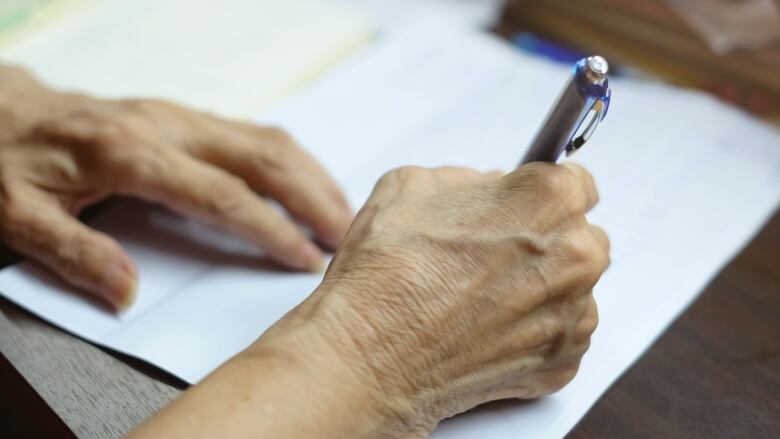 A person signs a piece of paper.