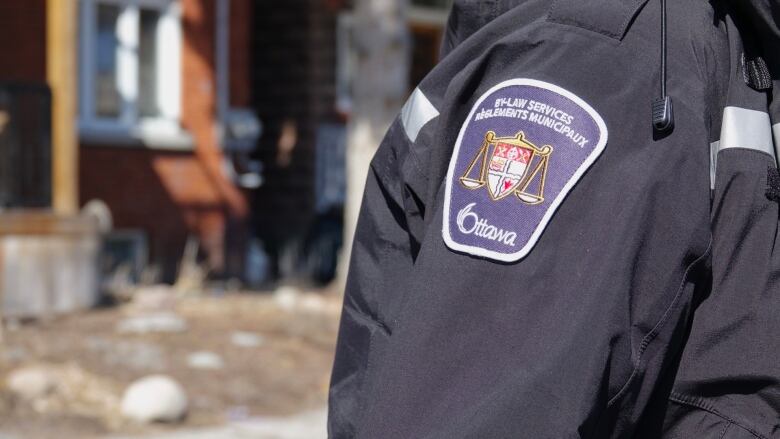 The patch on a bylaw officers jacket can be seen.