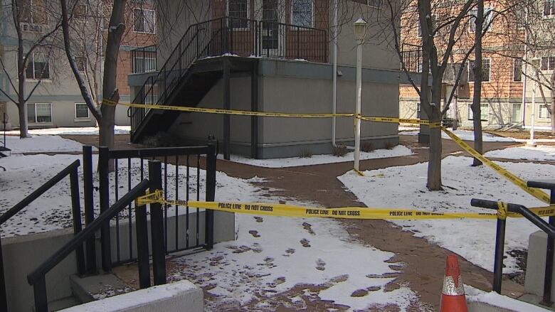 Police tape in front of an apartment building. 