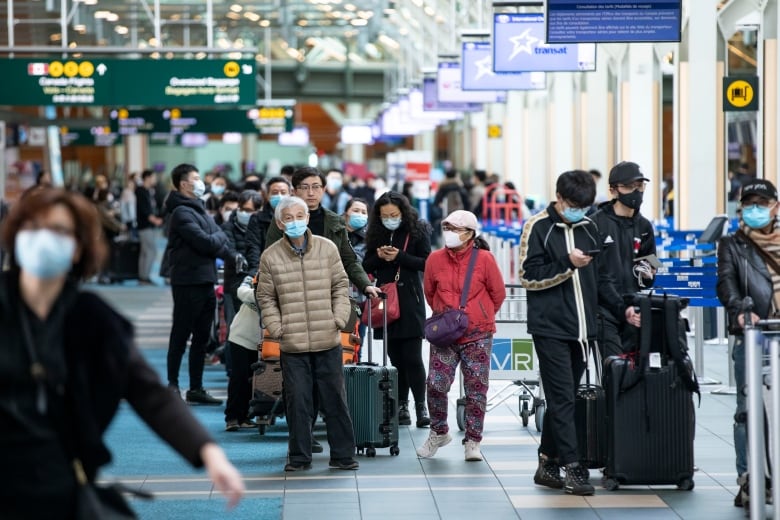 Passengers are pictured at the Vancouver International Airport (YVR) in Richmond, B.C., on March 17, 2020. 