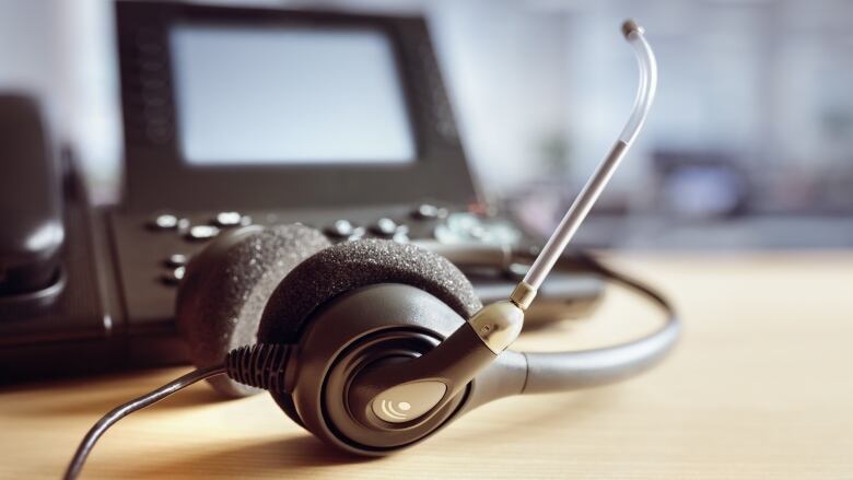 Headphones and a microphone in front of a computer monitor.