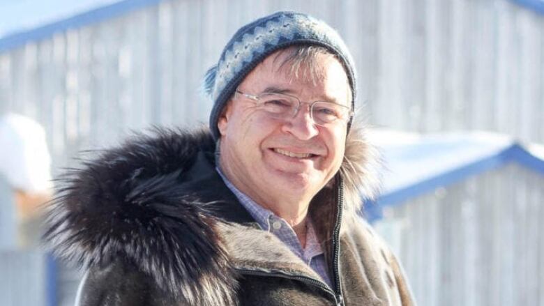 A portrait of a smiling man outdoors.