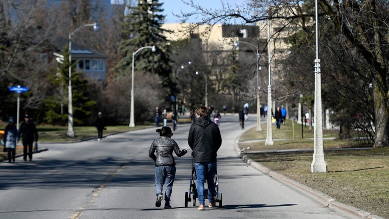 People walk side-by-side along the Queen Elizabeth Driveway in Ottawa.