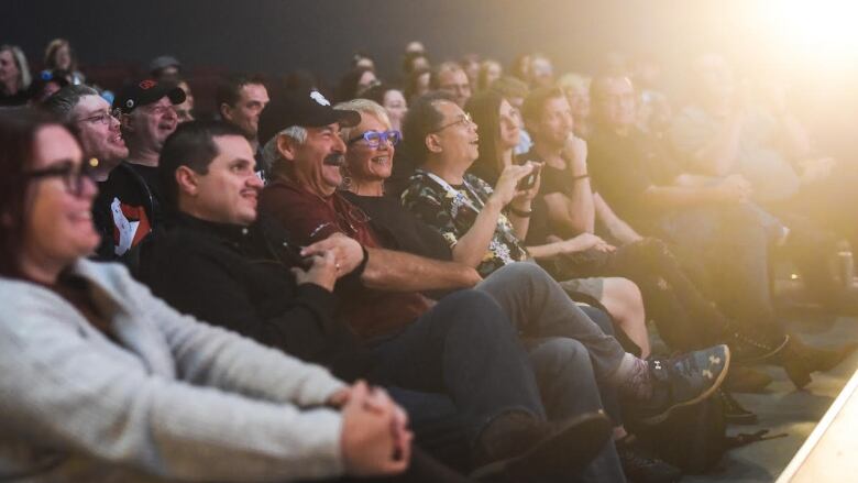 People sit in a theatre. 