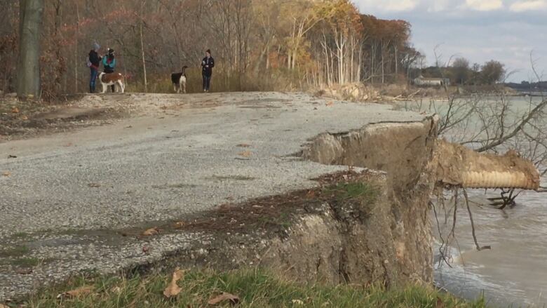 A chunk of a roadway crumbles into Lake Erie as water crashes into the shoreline. 