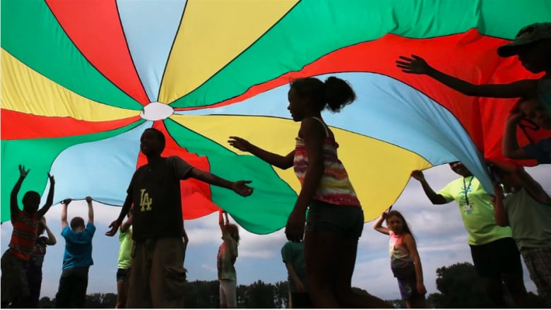 children playing under a rainbow fabric. 