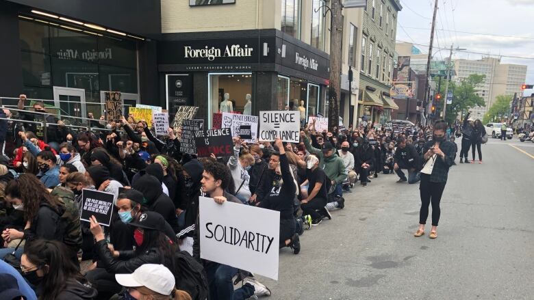 Demonstrators take a knee on Spring Garden Road in Halifax to protest the death of George Floyd.